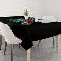 Black tablecloth with green graphic near the center and draped table edges