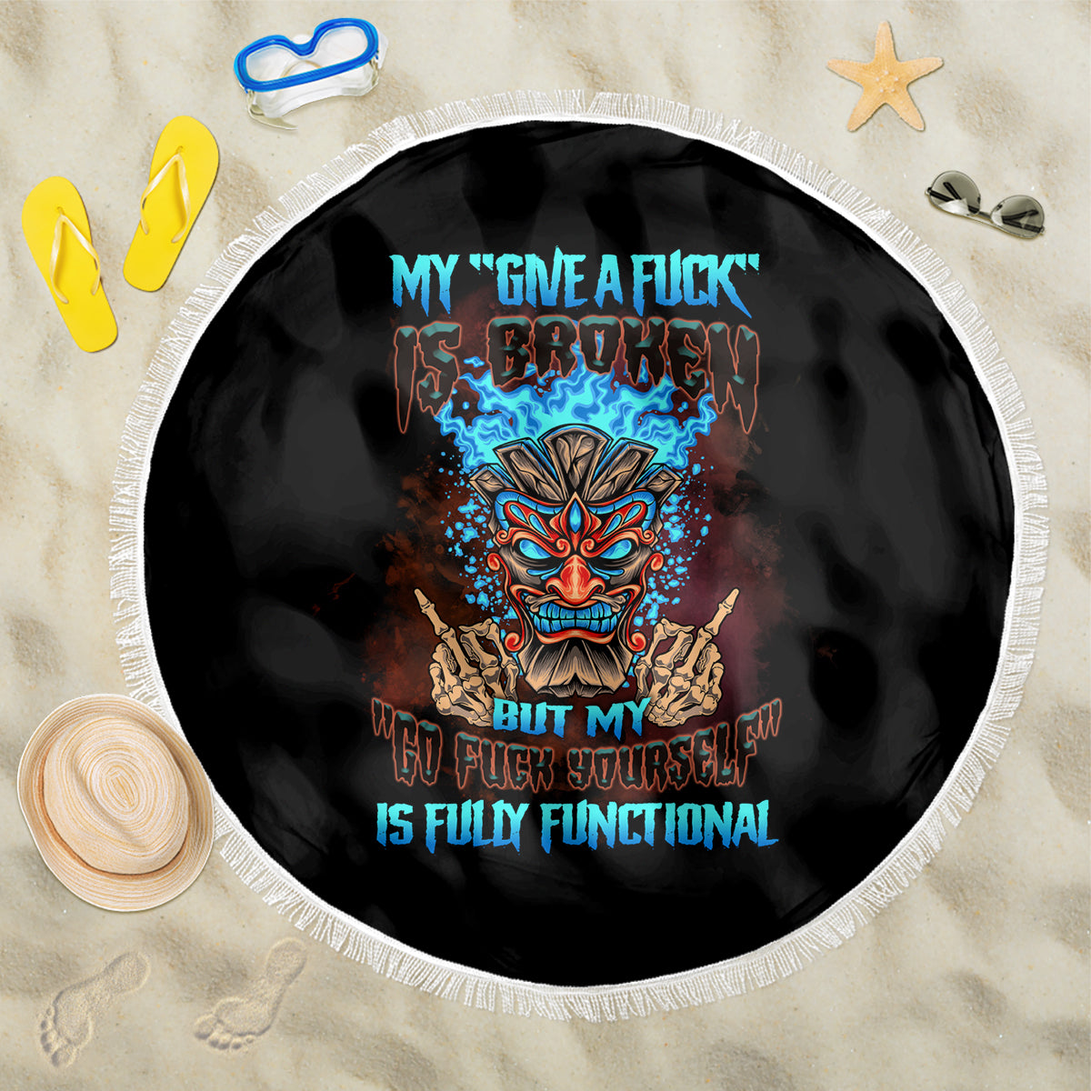 Black round beach blanket with white fringed edge featuring colorful tiki skull graphic