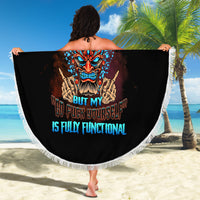 Black round beach blanket with white fringed edge held open, colorful tiki skull graphic