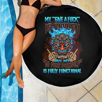 Black round beach blanket with white fringed edge and colorful tiki skull graphic