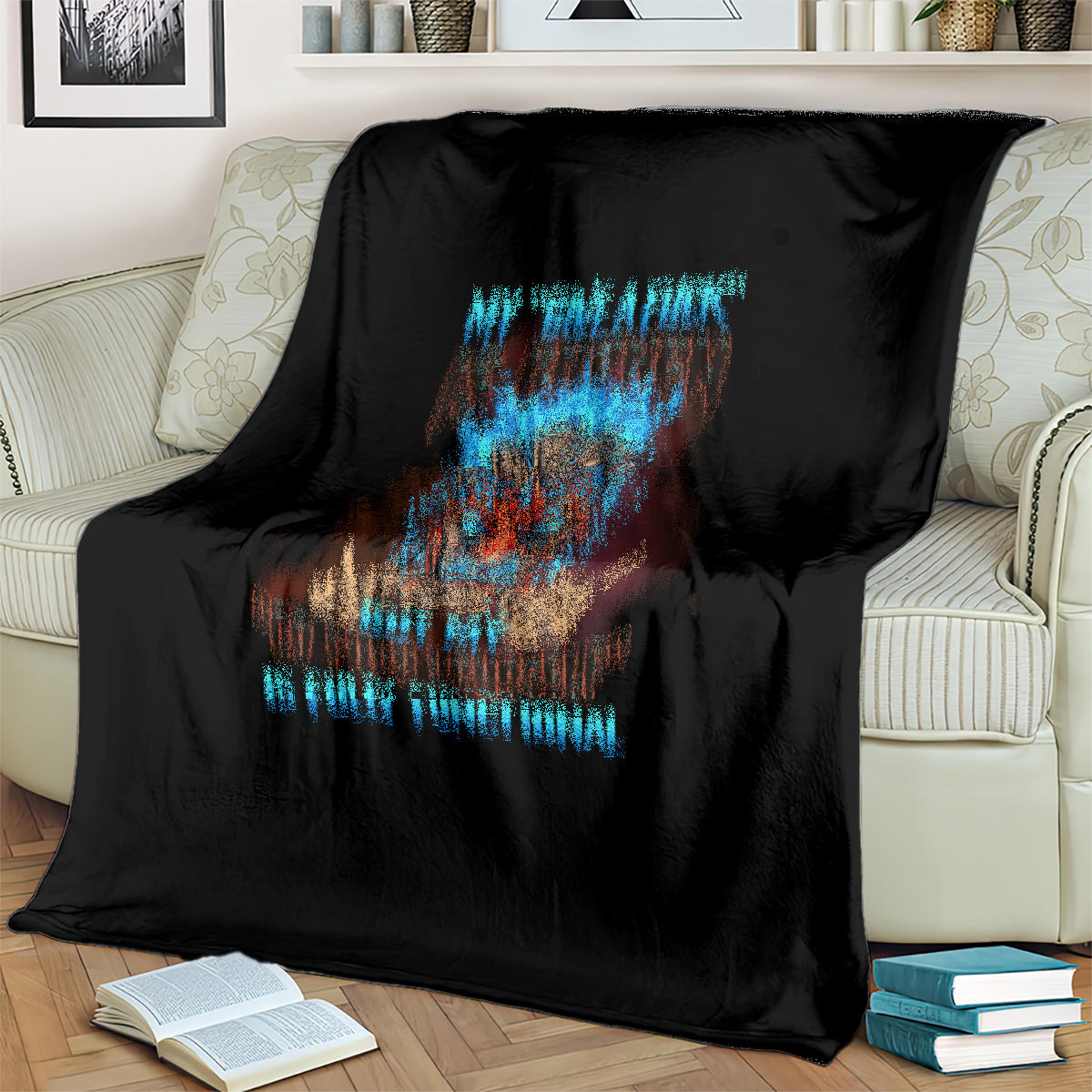 Black skull blanket with colorful tiki skull graphic and blue text, covering a couch