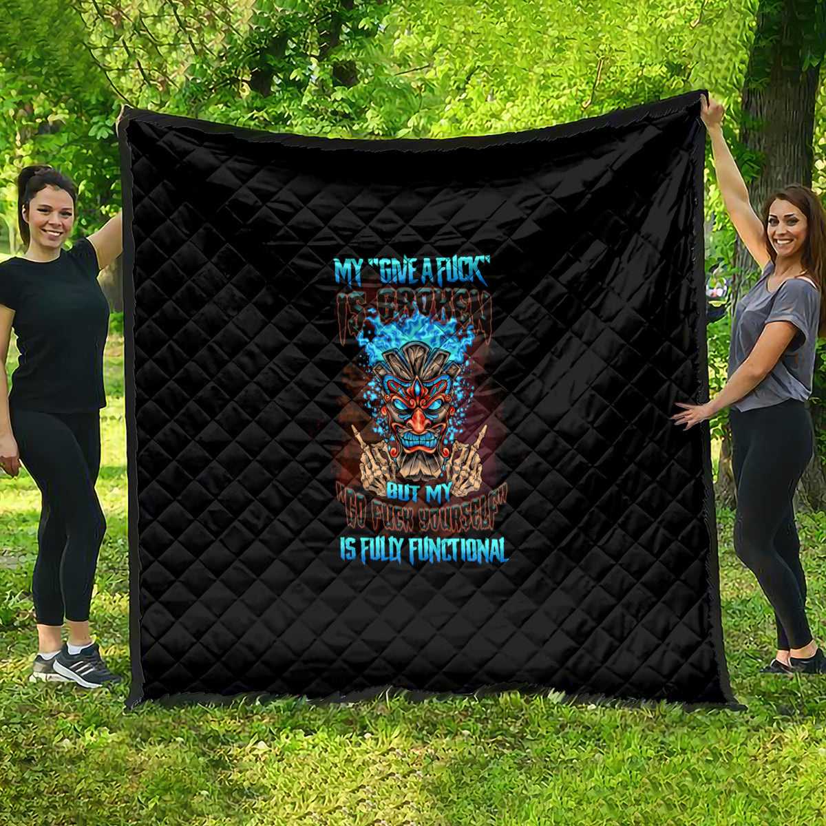 Black quilt with diamond stitching and colorful tiki skull graphic in the center