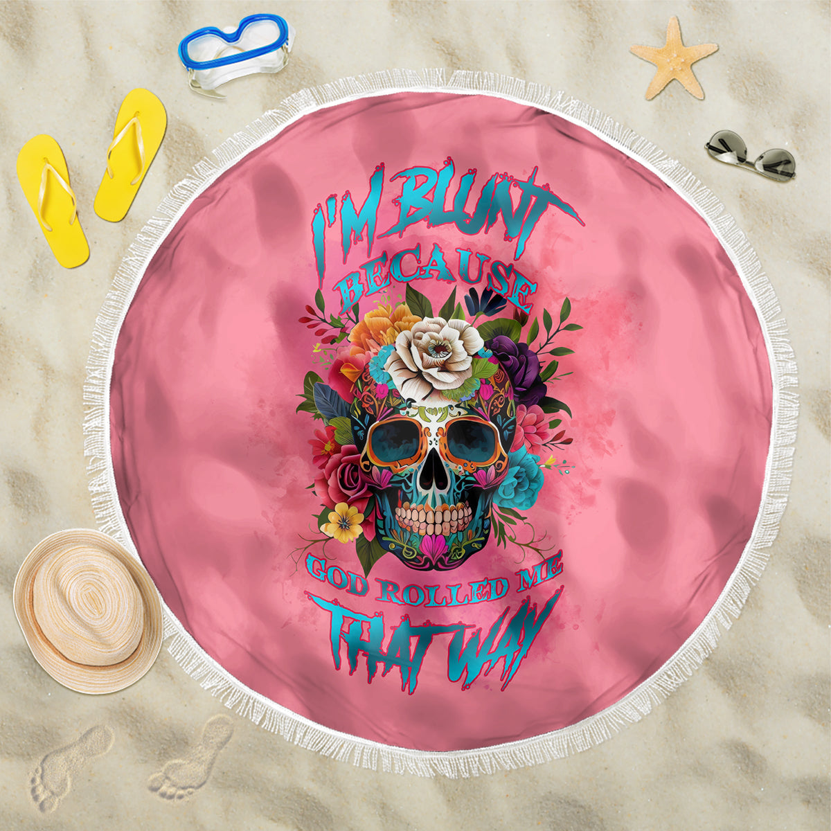 Round pink beach blanket with fringe, colorful skull floral artwork centered