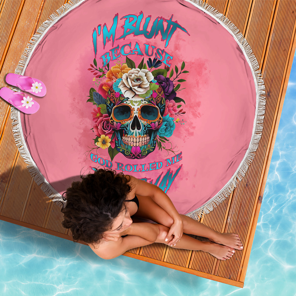 Round pink beach blanket with fringe edge, colorful skull and floral graphic