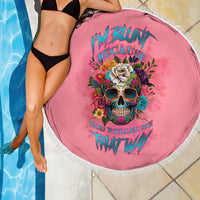 Round pink beach blanket with fringe, skull and flower graphic, shown beside pool