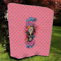 Pink quilt blanket with diamond quilted pattern and multicolor skull floral design