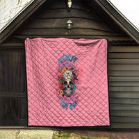 Pink quilt folded in doorway with diamond quilting and colorful skull floral design
