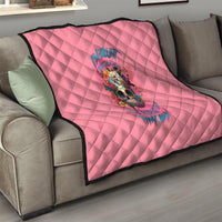 Pink quilt on sofa with diamond pattern and centered colorful skull floral artwork
