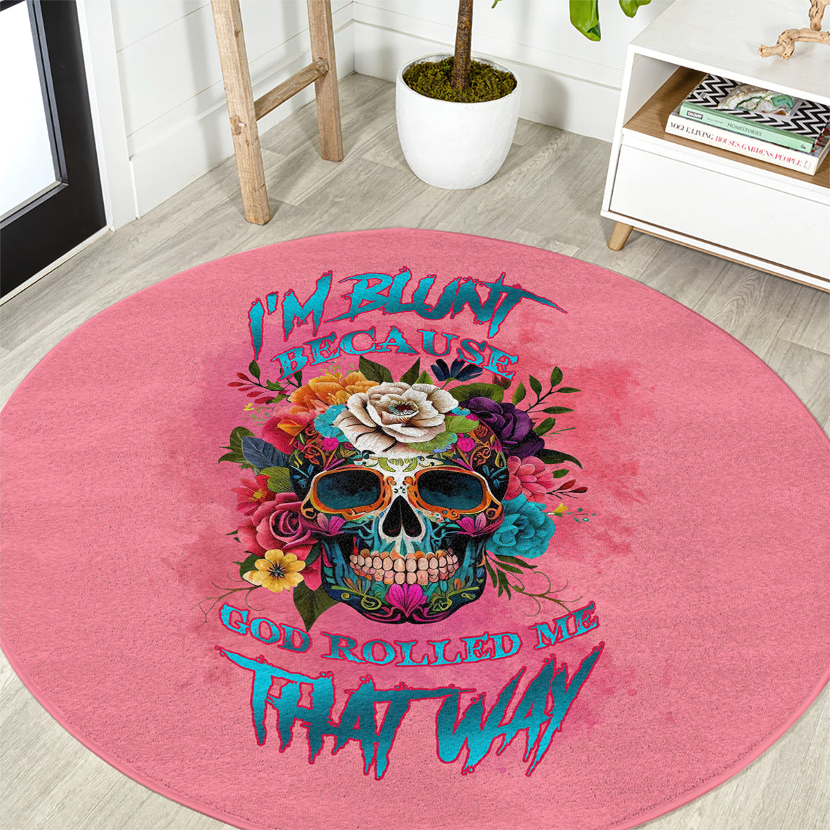 Pink round carpet rug featuring a detailed skull illustration with colorful stylized text