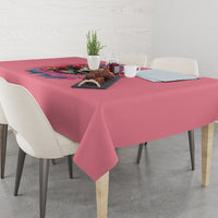 Pink tablecloth with colorful floral quote print, laid across a dining table.
