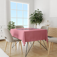 Pink tablecloth with colorful floral quote graphic on a dining table with chairs.