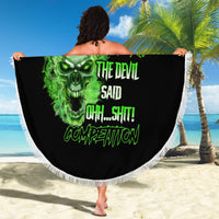 Round beach blanket held up in air, black with neon-green skull graphic and white fringe