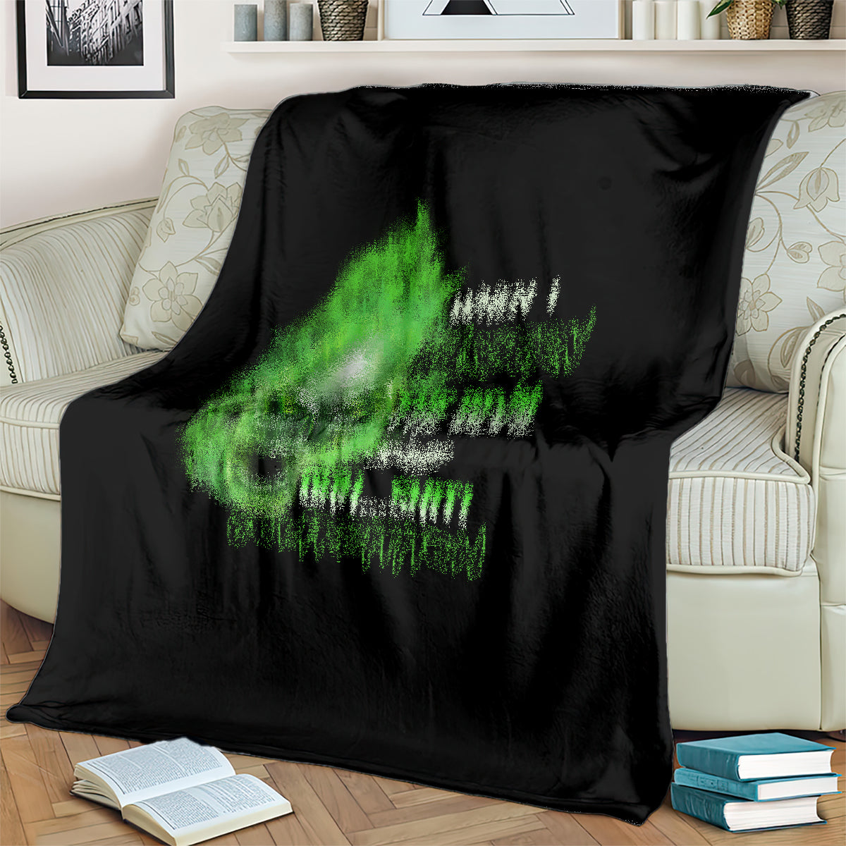Black throw blanket with green and white skull graphic on couch
