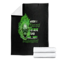 Black skull graphic blanket with green neon skull, folded with white towel