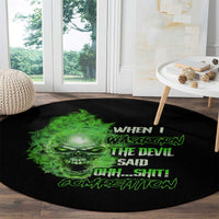 Black round carpet with green skull face and loud neon lettering on it