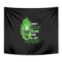 Black tapestry close-up with neon green skull face and phrase text, centered