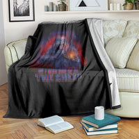 Black blanket draped on sofa with skull-and-rifle graphic and red-blue lettering