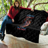 Black quilt blanket with diamond stitching and skull graphic laid over couch