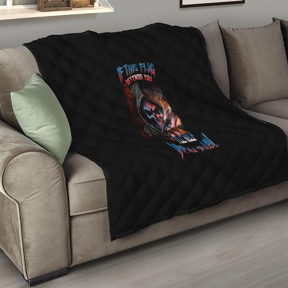 Black quilt blanket with diamond quilting and centered skull graphic on sofa