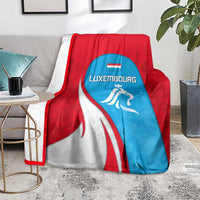 Luxembourg flag blanket with lion emblem, red white and blue panels on gray sofa