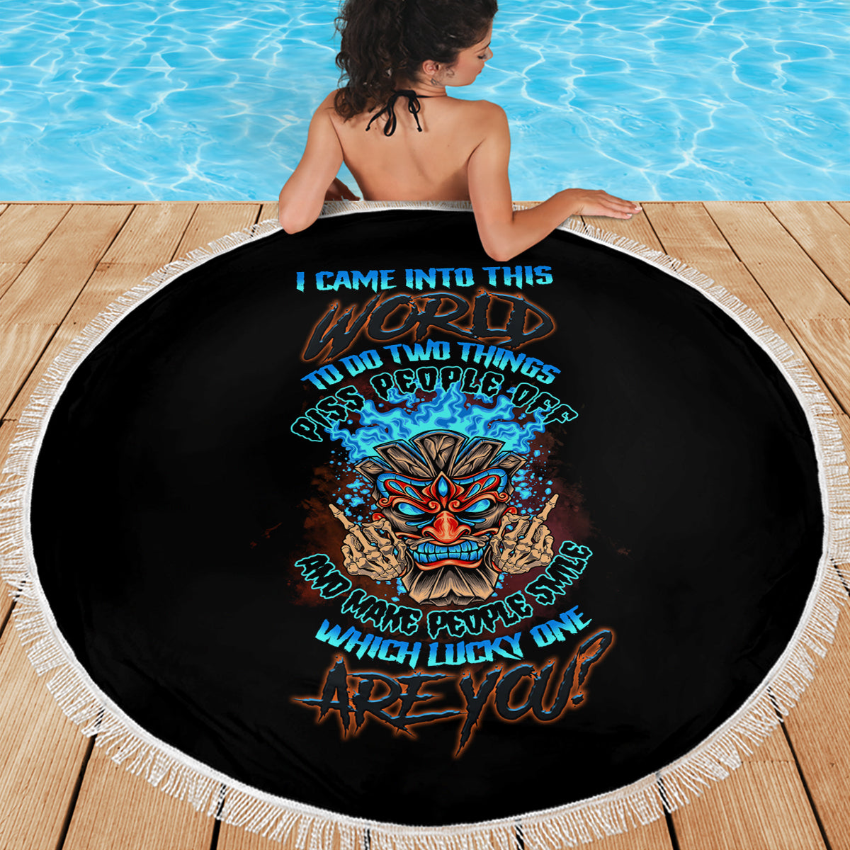 Round black beach blanket with white fringe and colorful tiki skull text logo