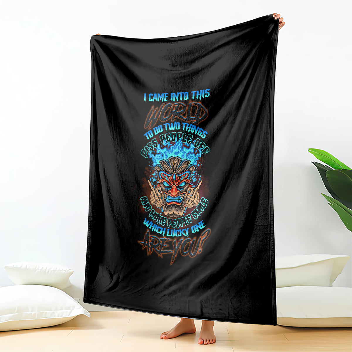 Black blanket with colorful skull tiki center graphic, draped over couch