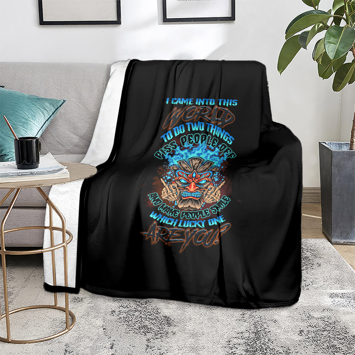 Black skull tiki graphic blanket with colorful lettering, on living room couch