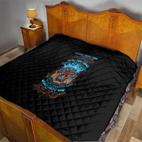Black diamond-quilted bedding quilt on bed with colorful tiki skull graphic