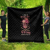 Black quilt blanket with diamond stitching and a pink flower skull graphic center