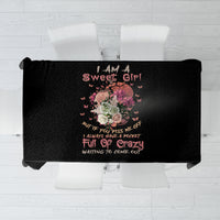 Black tablecloth laid flat, showing colorful flower-skull design and slogans