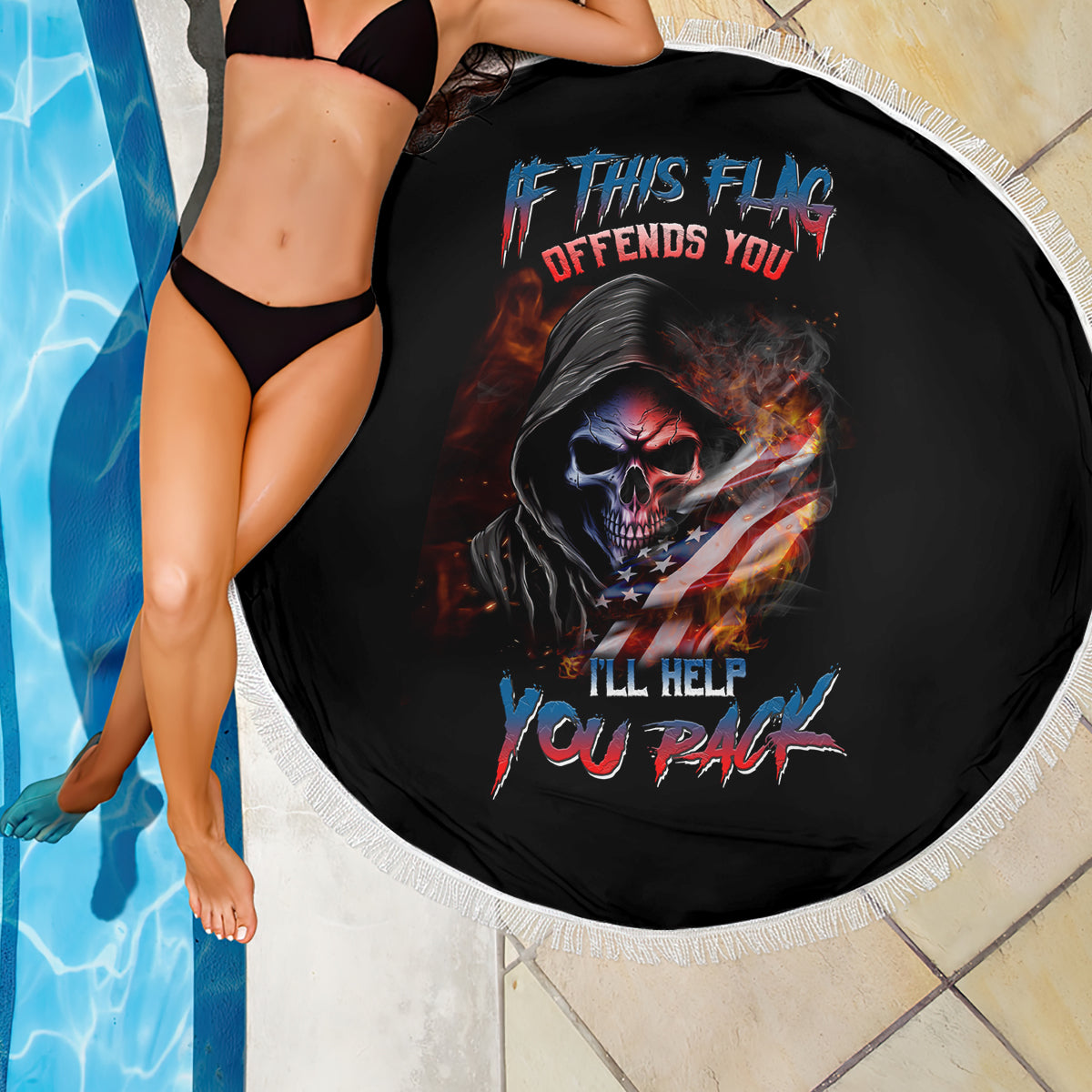 Black round beach blanket with skull and American flag graphic, white fringed edge