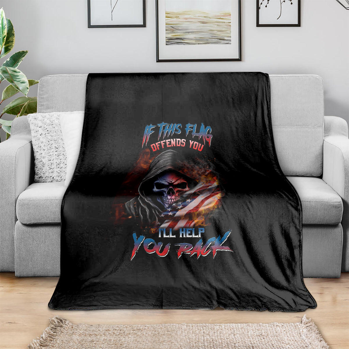 Black skull graphic blanket with multicolor slogan text, draped on sofa