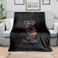 Black skull graphic blanket with multicolor slogan text, draped on sofa
