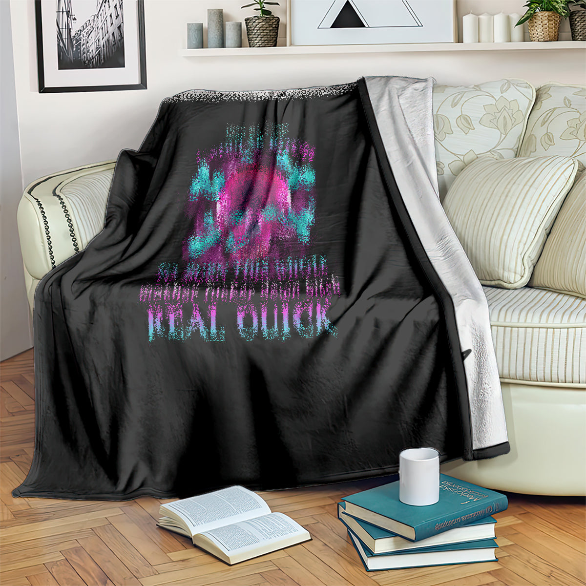 Black throw blanket with teal and magenta skull design on sofa