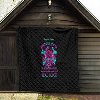 Black quilt with diamond stitching and colorful skull design, hung on an outdoor wall