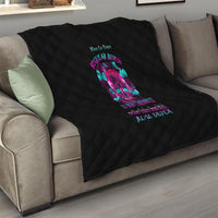 Black quilt with diamond stitching and colorful skull artwork draped over a sofa