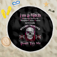 Black round beach blanket with fringe border featuring skull and crossed bones graphic