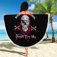 Round black beach blanket with fringe edge showing skull and crossed bones graphic