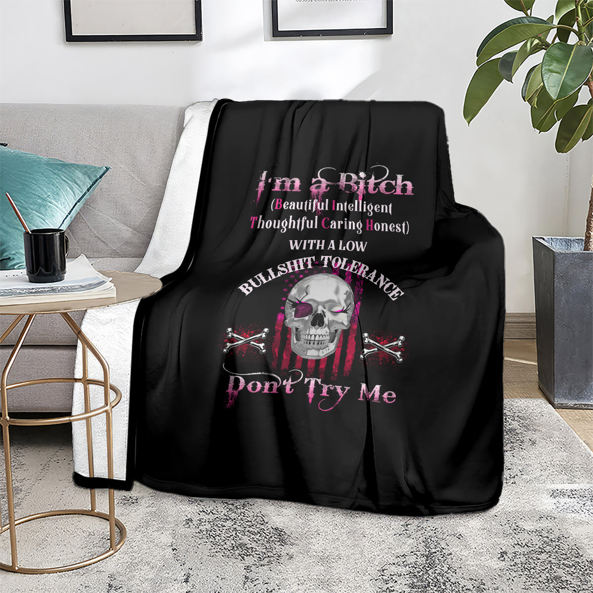 Black throw blanket on a couch with skull and crossed-swords graphic, 'Don't Try Me'