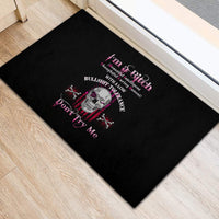Black rubber doormat with skull graphic and pink lettering, placed in room corner