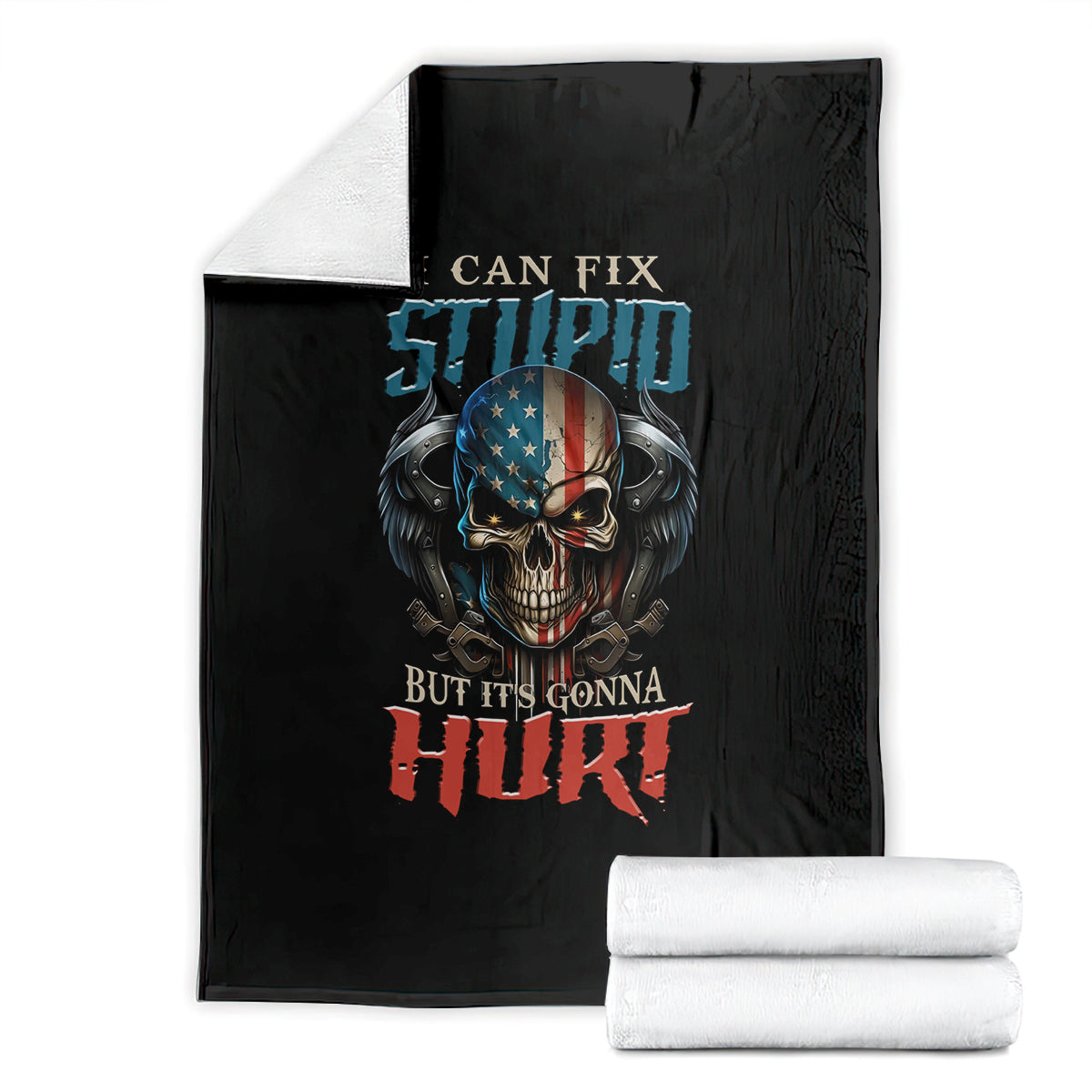 Black blanket with skull graphic, folded, beside a stack of white towels