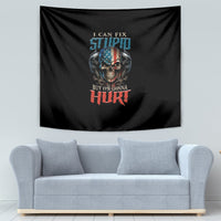 Black tapestry with skull and slogan, hung on a wall above a light gray sofa.