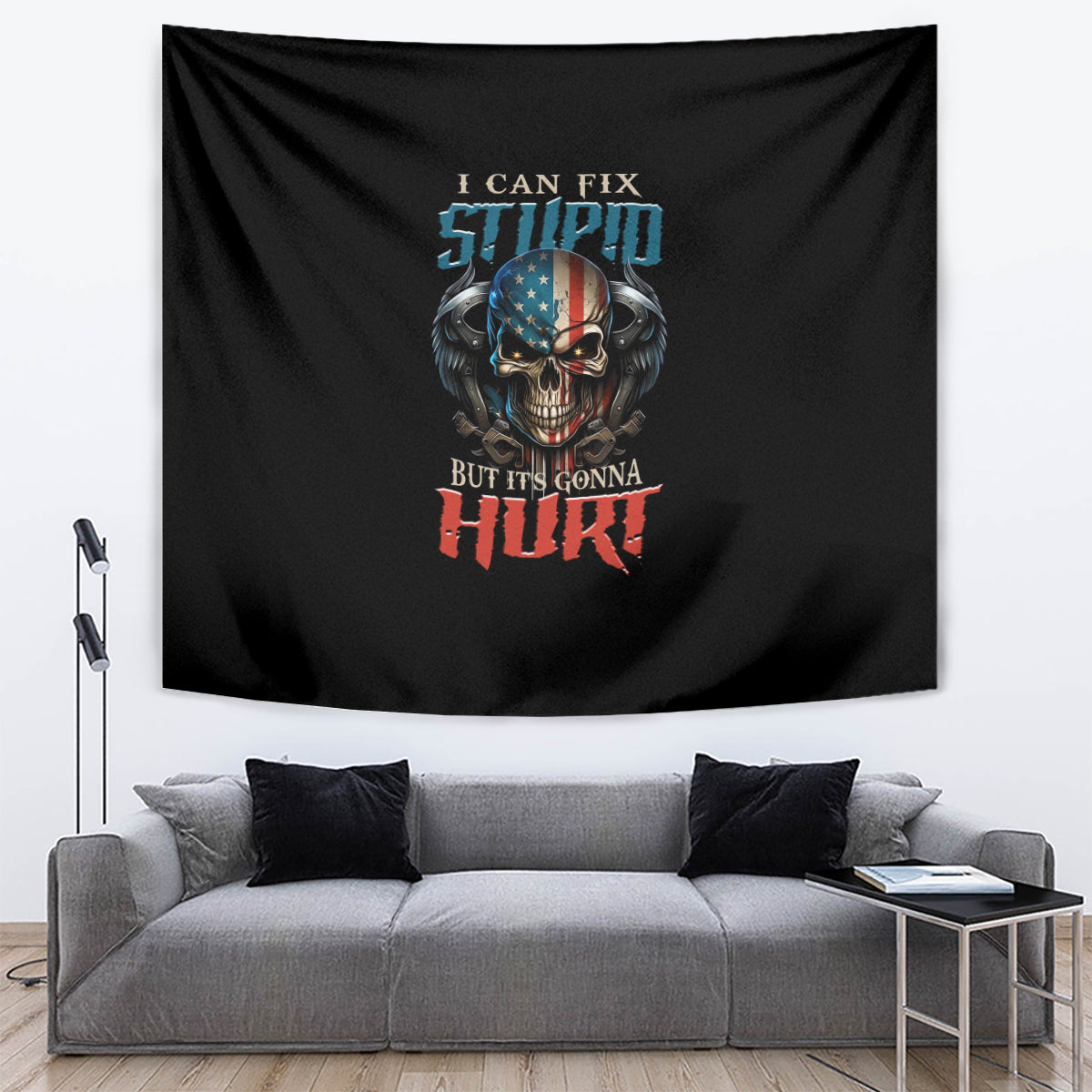 Black tapestry with skull and slogan, hanging on the wall above a gray sectional.