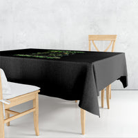 Black square tablecloth with green skull graphic, draped over a table corner