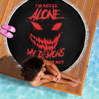 Black round beach blanket with red skull graphic and white fringe edge, 24/7 text