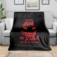 Black throw blanket with red skull and text graphic, laid on a sofa