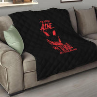 Black quilt blanket with red demon graphic on couch, diamond quilt pattern