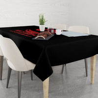 Black tablecloth with red demon graphic, set on dining table with cups and chairs