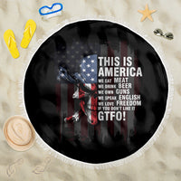 Round patriotic beach blanket with black skull-and-flag print, white fringe border
