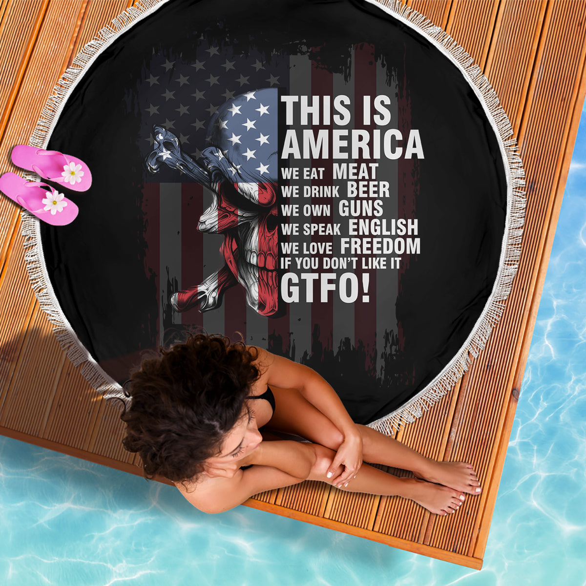 Round patriotic beach blanket, black with skull and American flag graphic, white fringe